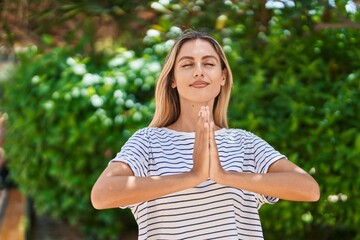 Canvas Print - Young blonde woman doing yoga exercise at park