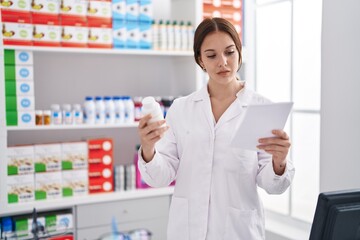 Poster - Young woman pharmacist reading prescription holding pills at pharmacy