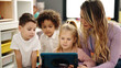 © Krakenimages.com - Woman and group of kids having lesson using touchpad at kindergarten