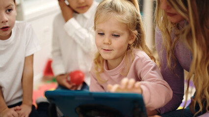 Poster - Woman and group of kids having lesson using touchpad at kindergarten