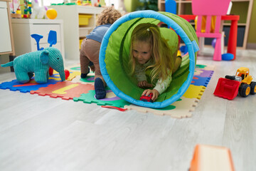 Sticker - Adorable boy and girl sitting on floor playing at kindergarten