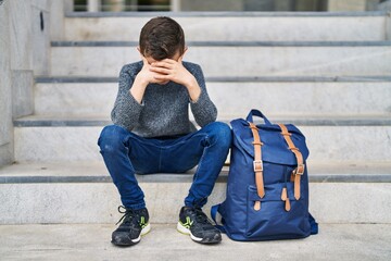 Poster - Blond child student with worried expression sitting on stairs at school