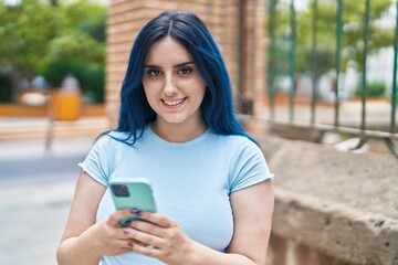 Poster - Young caucasian woman smiling confident using smartphone at street