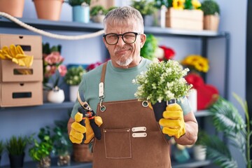 Sticker - Hispanic man with grey hair working at florist shop skeptic and nervous, frowning upset because of problem. negative person.