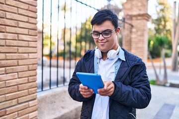 Wall Mural - Down syndrome man wearing headphones using touchpad at street