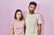 © Krakenimages.com - Young hispanic couple together over pink background skeptic and nervous, frowning upset because of problem. negative person.