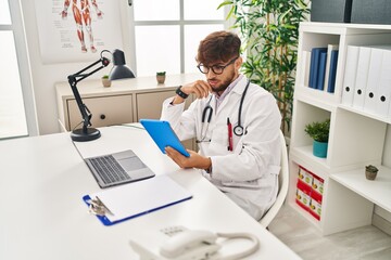 Canvas Print - Young arab man wearing doctor uniform using touchpad at clinic