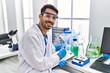 © Krakenimages.com - Young hispanic man wearing scientist uniform writing on clipboard working at laboratory