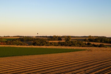 Poster - Beautiful view of cultivated farmland with cloudless sky at sunset