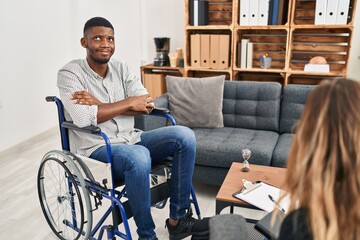 Poster - African american man doing therapy sitting on wheelchair smiling looking to the side and staring away thinking.