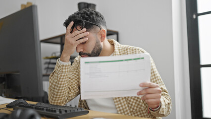 Sticker - Young hispanic man business worker stressed reading document at office