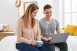 © Krakenimages.com - Man and woman mother and son drinking coffee using laptop at bedroom
