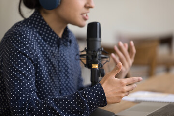 Close up young woman blogger in headphones lead livestream online chat with subscribers, provide information, share experience with channel followers. Livestream event, radio host employee workflow