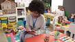 © Krakenimages.com - African american woman preschool teacher smiling confident writing on document at kindergarten