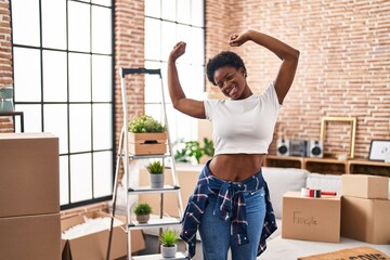 Wall Mural - African american woman smiling confident stretching arms at new home