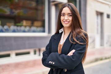 Poster - Young beautiful hispanic woman standing with arms crossed gesture at street