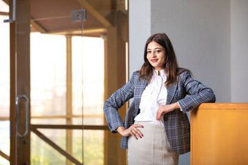 Wall Mural - Young and confident corporate woman standing at office.