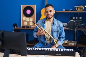 Sticker - Young hispanic man musician smiling confident holding trumpet at music studio