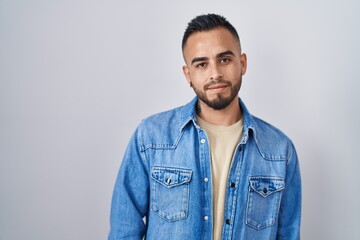 Canvas Print - Young hispanic man standing over isolated background looking sleepy and tired, exhausted for fatigue and hangover, lazy eyes in the morning.