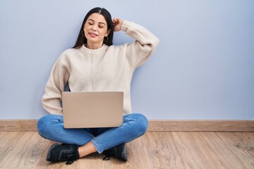 Sticker - Young woman using laptop sitting on the floor at home stretching back, tired and relaxed, sleepy and yawning for early morning