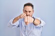 © Krakenimages.com - Middle age caucasian man standing over blue background punching fist to fight, aggressive and angry attack, threat and violence