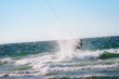 Man riding a kite surfboard on bright sunny day at sea