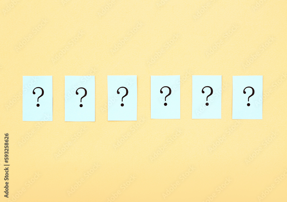 Papers with question marks on yellow background