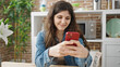 © Krakenimages.com - Young beautiful hispanic woman using smartphone sitting on table at dinning room