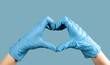 © valiantsin - Hands in blue gloves showing heart-shaped fingers on background