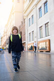 Fototapeta Na drzwi - happy boy student in black clothes with a backpack walks around the city