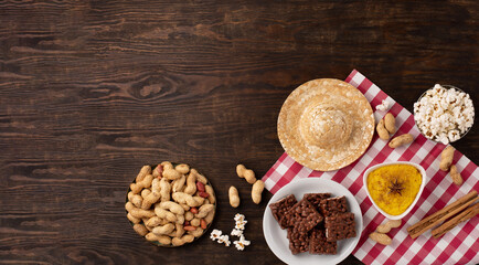 Brazilian straw hat, popcorn, peanuts and colorful flags on wooden background for Brazilian Festa Junina Summer Festival