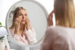 © Prostock-studio - Skin Problems Concept. Upset Middle Aged Woman Looking At Mirror And Touching Face,