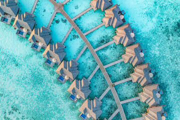 Canvas Print - Aerial sunset landscape, luxury tropical resort water villas. Beautiful island beach, palm trees, orange sunrise sea sky. Amazing bird eyes view Maldives paradise  tropical bay. Exotic summer vacation