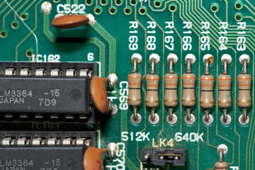 Upper detail of the components of an old computer motherboard with chips and resistors