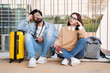 © Prostock-studio - Tired sad millennial indian guy and caucasian woman tourists sit with suitcase and camera, rest, thinking