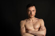 © vladorlov - Adult attractive man with a beautiful body posing in the studio. Black background.