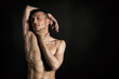 © vladorlov - Adult attractive man with a beautiful body posing in the studio. Black background.