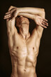 © vladorlov - Adult attractive man with a beautiful body posing in the studio. Black background.