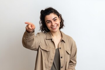 Wall Mural - Portrait of a smiling young woman pointing finger to the side. Generative AI