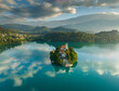 Aerial view of sunrise at Bled lake, Slovenia. Flying around island with Church of the Assumption of Mary in Bled lake surrounded by mountains