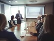 © Jonas - CEO presenting to attentive colleagues in a boardroom.