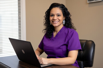 Portrait of a stunning Physical Therapy Assistant with curly black hair, wearing a purple scrubs top and sitting at a desk with a laptop, generative ai
