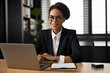 © aicandy - Smart and confident paralegal sitting at a desk, wearing glasses and working on a laptop, generative ai
