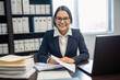 © aicandy - Smiling paralegal sitting at a desk with a laptop and legal documents spread out in front of her, generative ai