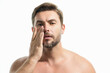 © Volodymyr - Beauty close up portrait of handsome man with moisturizing cream on face, isolated background. Skincare routine concept. Male haircut, mustache and beard. Male beauty. Shaving, hair styling.