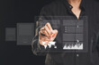 © meeboonstudio - Businessman uses a stylus pen to sign electronic documents on a virtual screen while standing on a black background