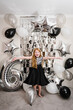 © Serhii - Happy kid celebrating a birthday party 6 years. Photo wall, photo zone decoration white, black, silver balloons. Idea decor an arch in luxury style. Celebration concept. Reception at birthday party.