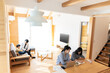 © milatas - リビングで遊ぶ父子と作業をする母子