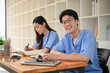 © bongkarn - Handsome and smart young Asian male medical student in a uniform studying with his friend