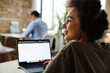 © Drobot Dean - African woman working on laptop computer while sitting in office